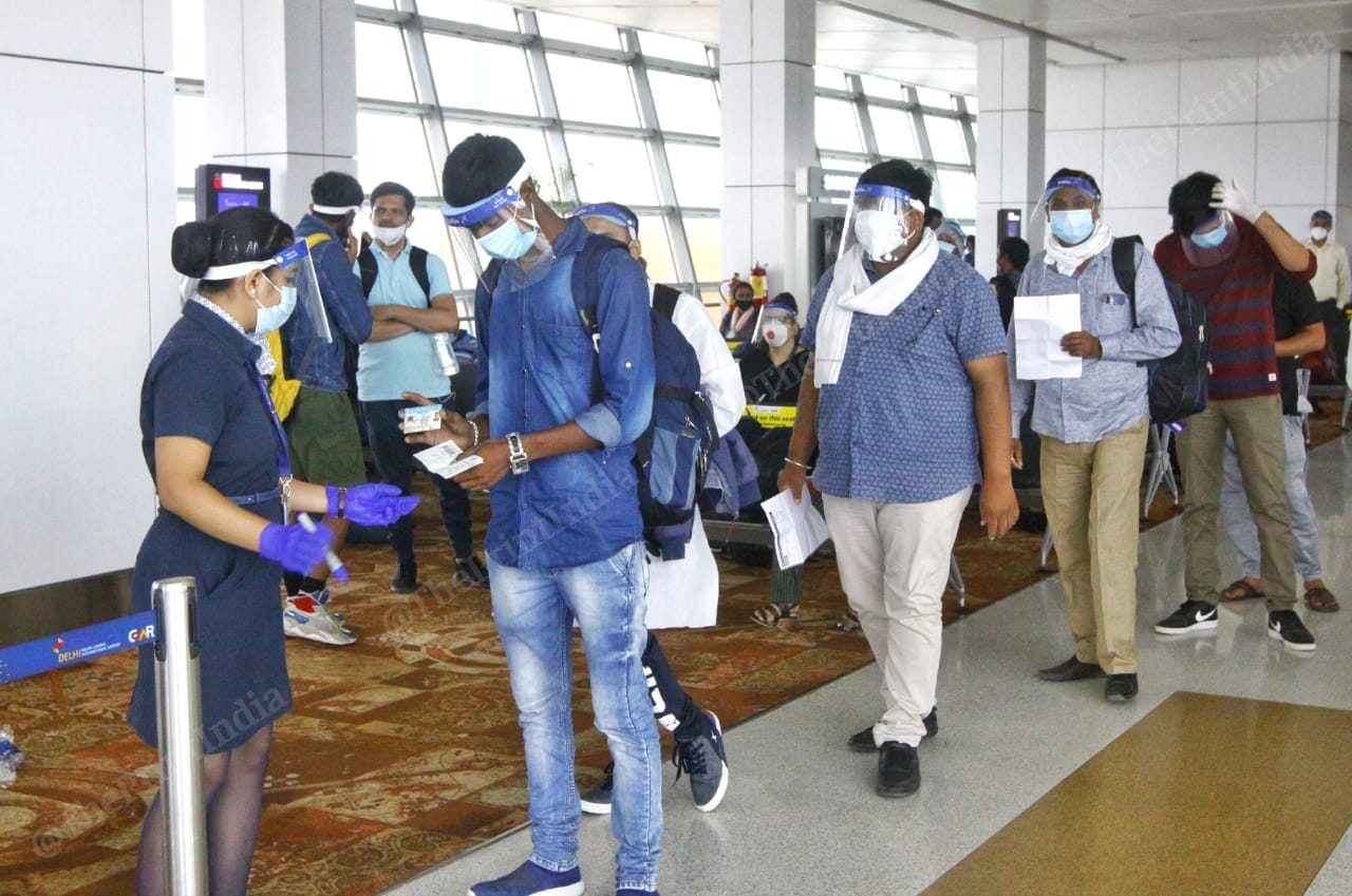 Passengers maintain physical distance from each other as they show their boarding pass and ID cards to the IndiGo crew before boarding the flight | Praveen Jain | ThePrint