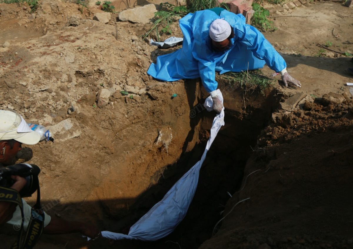 He was laid in rest by Shamim and Wasim in PPE kit) | Photo: Manisha Mondal | ThePrint