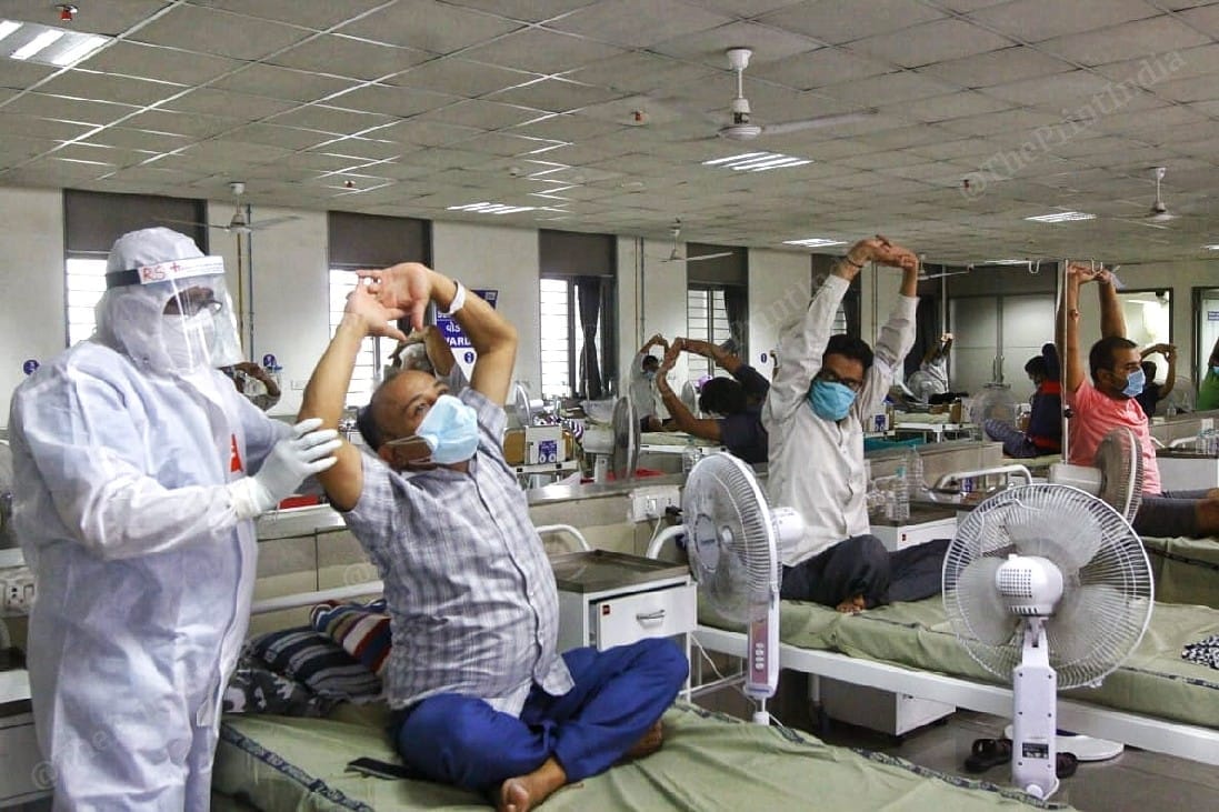 Another doctor helps a Covid-19 patient to stretch better while doing yoga | Photo: Praveen Jain | ThePrint