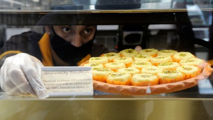 A sweet shop employee places a sign in front of their 'Immunity Sandesh', in Kolkata in June | ANI