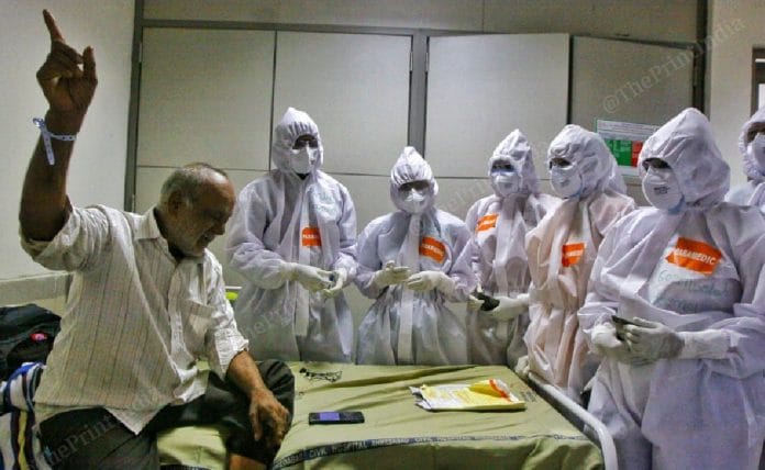 Amrit Bhai Panchal, a 64-year-old Covid-19 patient, sings 'Gulaabi aankhein' for a group of doctors and paramedics to lighten the mood | Photo: Praveen Jain | ThePrint