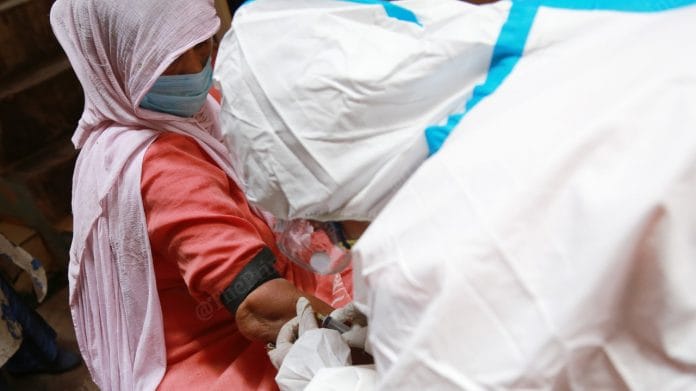A health worker draws blood sample