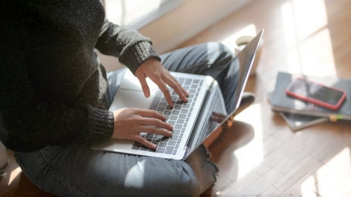 Woman sitting on the floor working on her laptop | Pexels