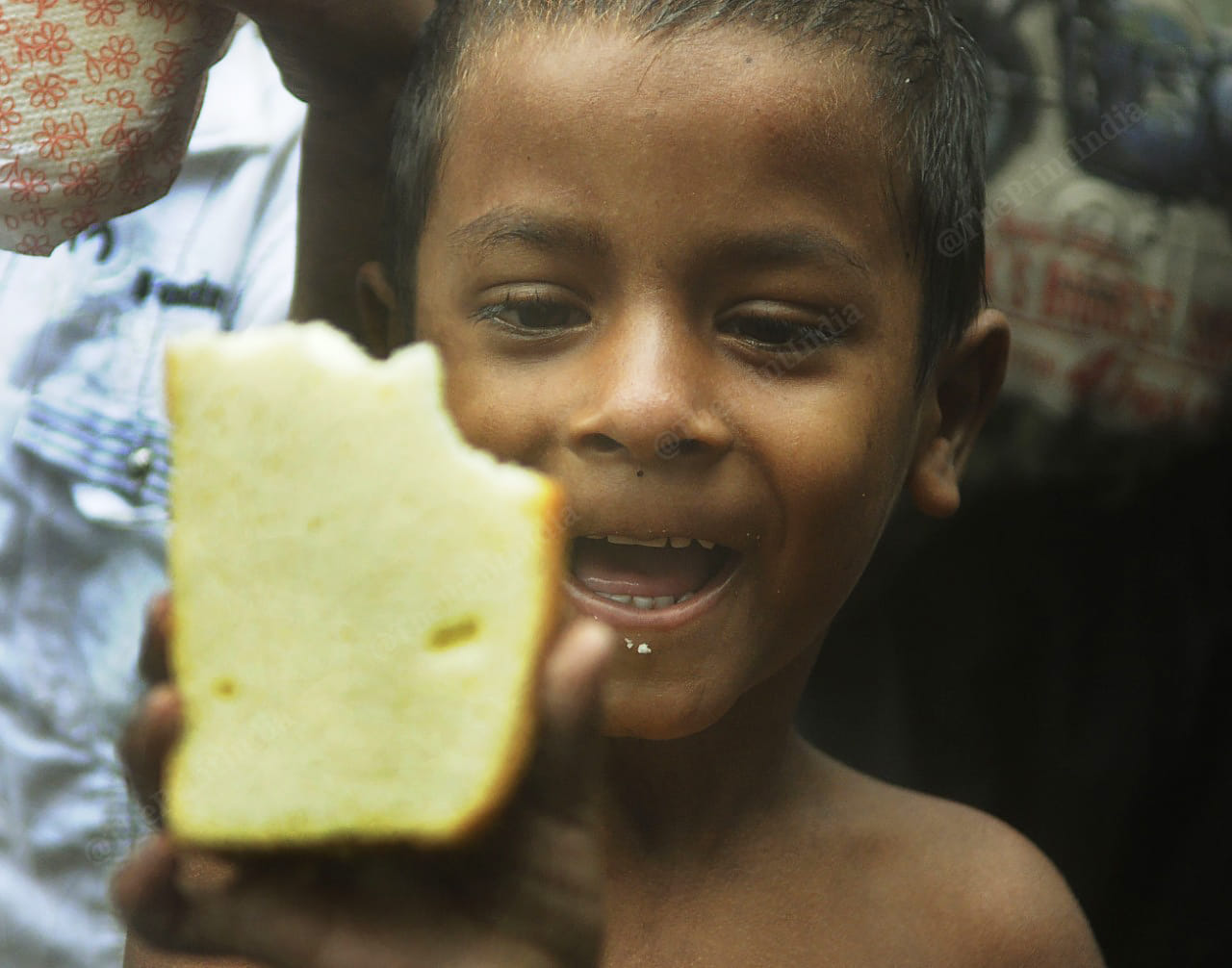 A kid smiles as he receives cake and balloons on Mother's birthday | Photo: Ashok Nath Dey | ThePrint