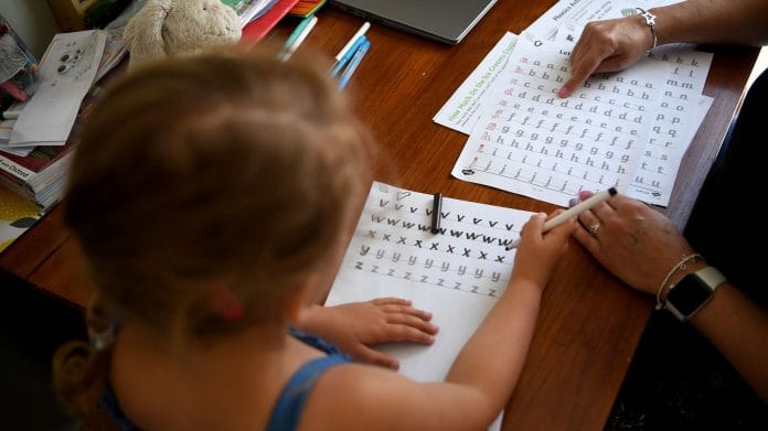 A girl studying at home with her mother (Representational Image) | Photo by Gareth Copley | Getty Images via Bloomberg