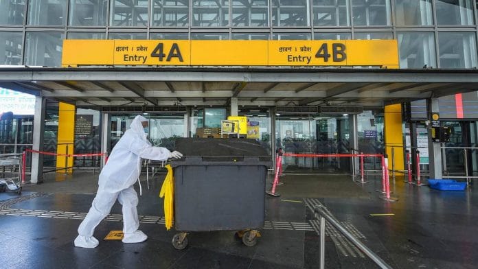 A worker in a PPE kit pushes a cart at deserted NSCBI Airport during the biweekly lockdown in Kolkata on 20 August 2020 | Ashok Bhaumik | PTI
