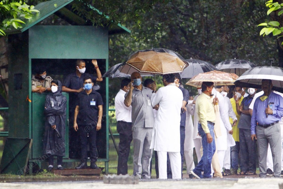 On the day of 76 anniversary of Rajiv Gandhi, it was raining heavily in Delhi, all security guards take shelter under the tree and the canopy | Photo: Praveen Jain | ThePrint