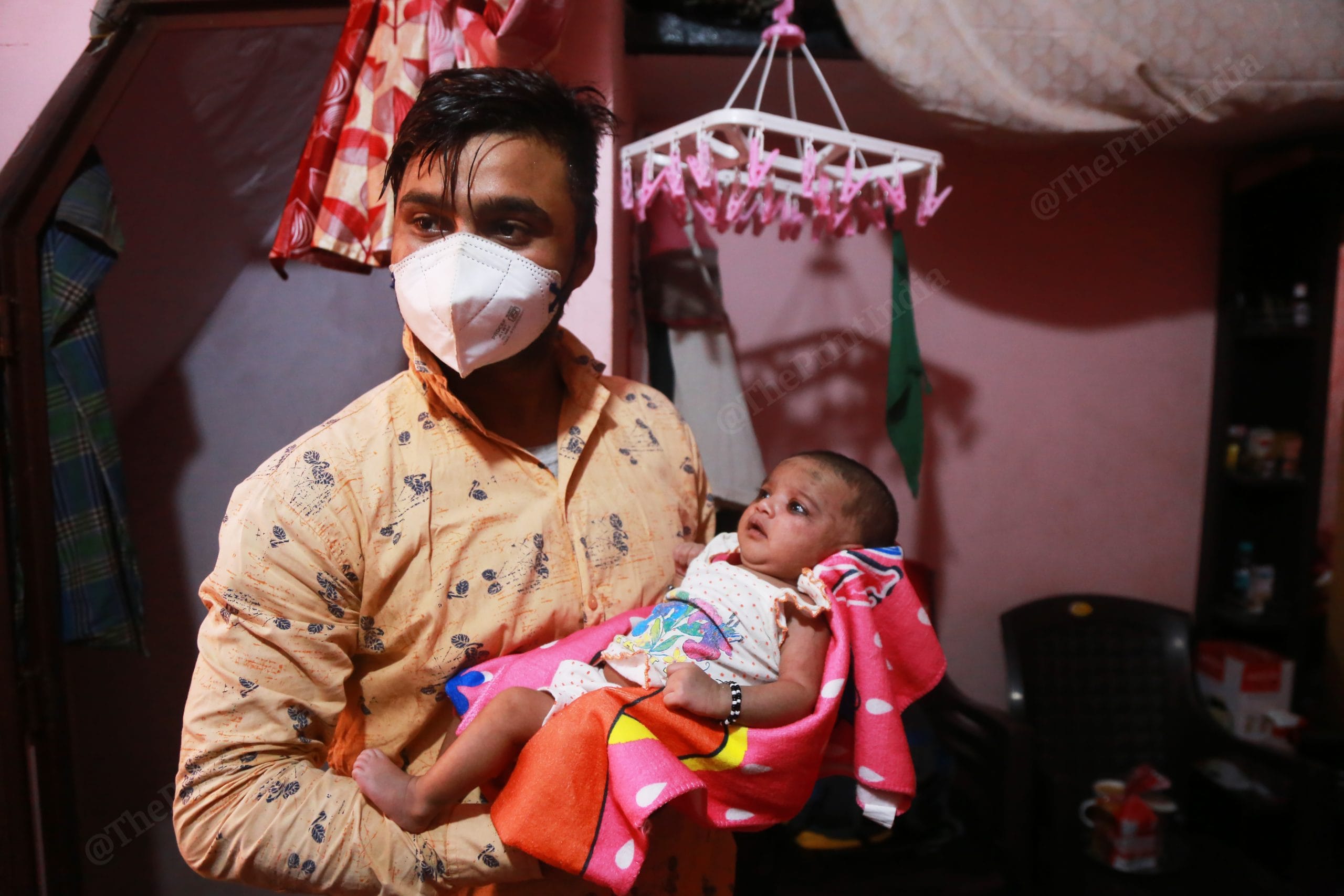 Ansar carries his daughter Insayah in his arms. | Photo: Manisha Mondal/ThePrint 