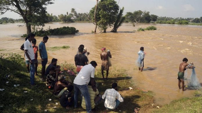 Villagers looks on the overflowing flooded water as they enter into the agricultural land near Pipli, Odisha, on 30 August 2020 | ANI