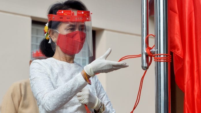 Myanmar's de-facto leader Aung San Suu Kyi wears a face shield and a mask during a flag-raising ceremony in Naypyidaw on 8 September | Photo: Thet Aung | AFP/Getty Images via Bloomberg