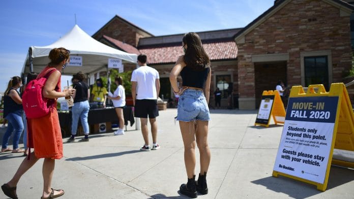Incoming freshmen wait in line to ask questions at an informational tent while arriving on campus at University of Colorado Boulder on August 18