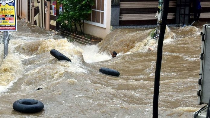 People throw tyre tubes to save a man being carried away by gushing waters in the Falaknuma area of Hyderabad Wednesday | ANI