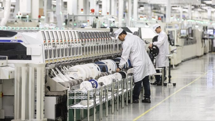 Employees work on the assembly line of a Huawei Technologies Co. mobile phone plant in Dongguan, China | Bloomberg