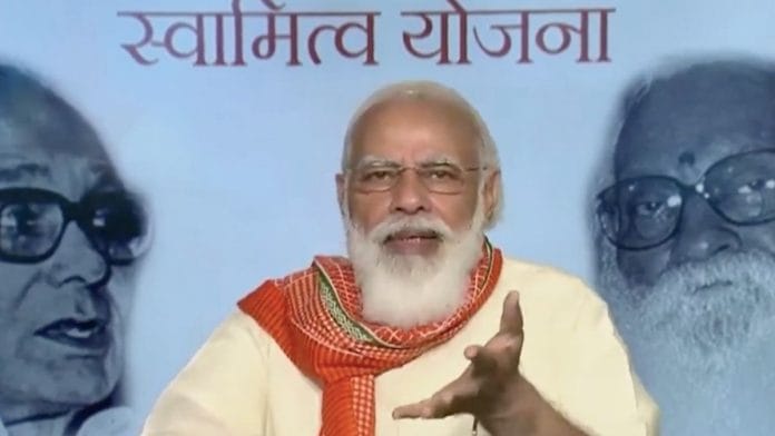 PM Narendra Modi announces Svamitva scheme via video conferencing Sunday, on the occasion of the birth anniversaries of Jayaprakash Narayan (backdrop, left) and Nanaji Deshmukh (right)