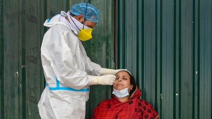 A health worker wearing PPE kit collects sample from a woman for COVID-19 test, at Chanpora, in Srinagar, Thursday, Oct. 1, 2020 | Representational image | PTI