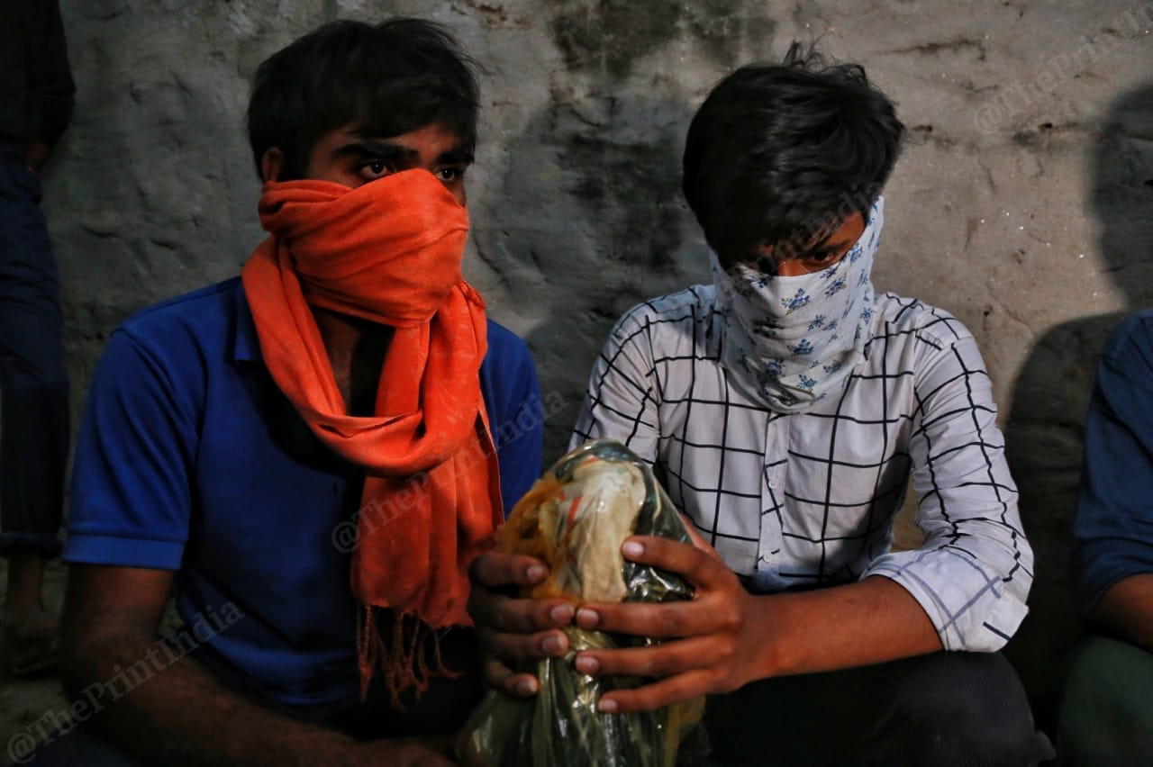 The two brothers of the Hathras victim hold her ashes three days after the body was cremated in an open field allegedly against the family's wishes in Hathras, Uttar Pradesh | Photo: Manisha Mondal | ThePrint