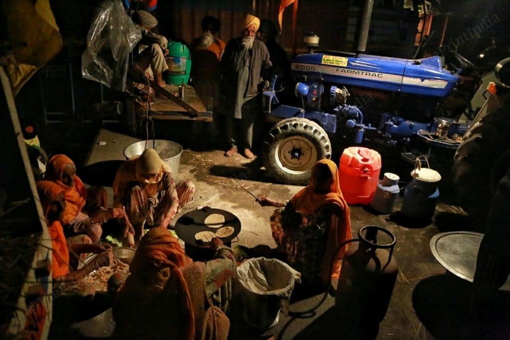 Farmers serving food, while women make chapattis | Photo: Manisha Mondal | ThePrint