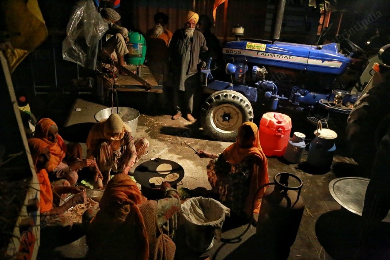 Farmers serving food, while women make chapattis | Photo: Manisha Mondal | ThePrint