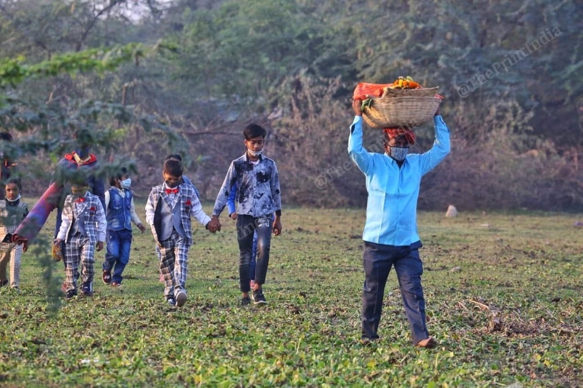 People sneakily cross the field | Photo: Praveen Jain | ThePrint