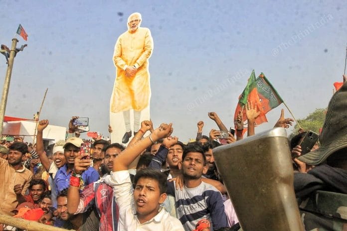 A BJP supporter seen holding a placard of Narendra Modi during the election rally in Darbanga | Praveen Jain | ThePrint