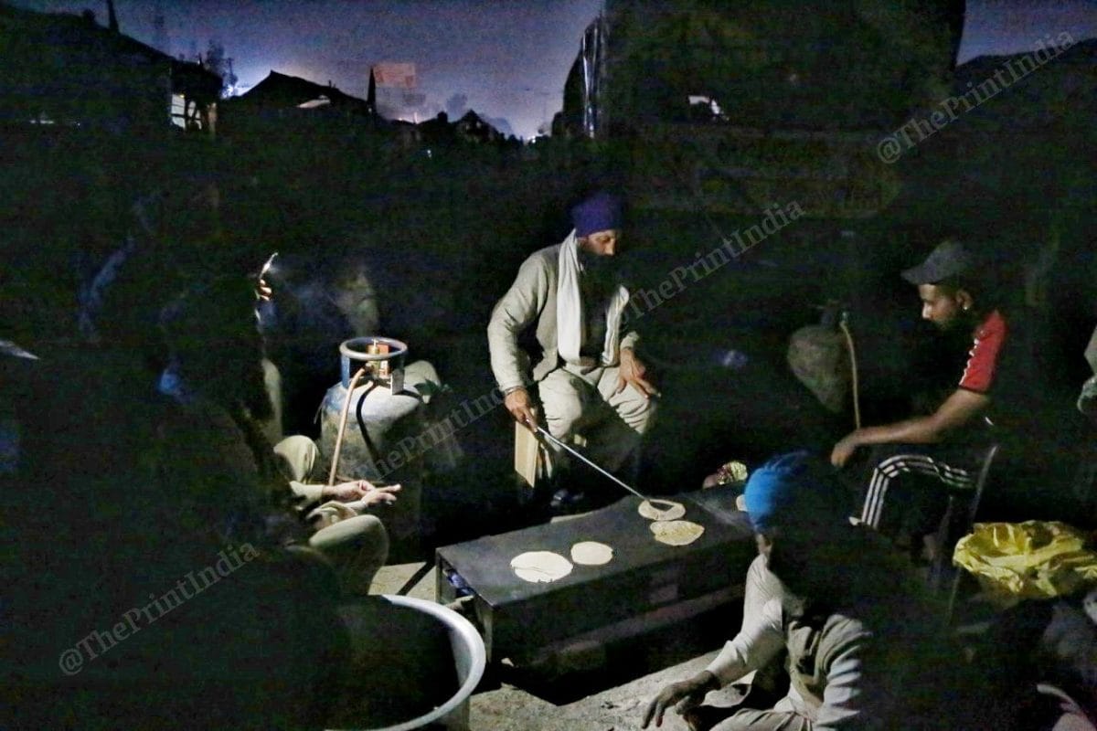 A group of farmers chant Satnam Waheguru Ji while preparing dinner | Photo: Manisha Mondal | ThePrint