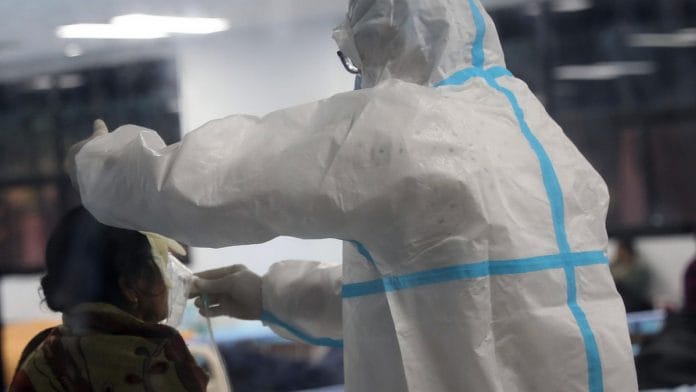 Representational image of a health worker fitting an oxygen mask to a Covid-19 patient in Delhi | Photo: ANI