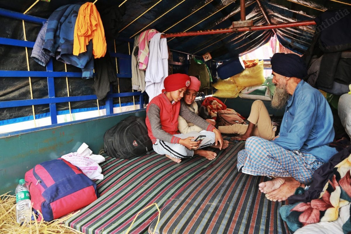 Gursewak Singh inside his tractor studying | Photo: Manisha Mondal | ThePrint
