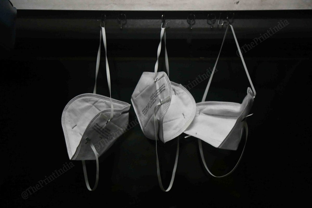 While travelling from New Delhi railway station to Vijaywada in Andhra Pradesh, three members of a family hang masks on hooks that would otherwise hold curtains in the AC compartment of a Rajdhani train | Manisha Mondal | ThePrint