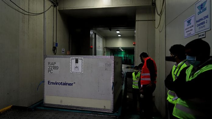 Workers transport an Envirotainer, a temperature-cooled container, at Indira Gandhi International Airport in New Delhi on 22 December