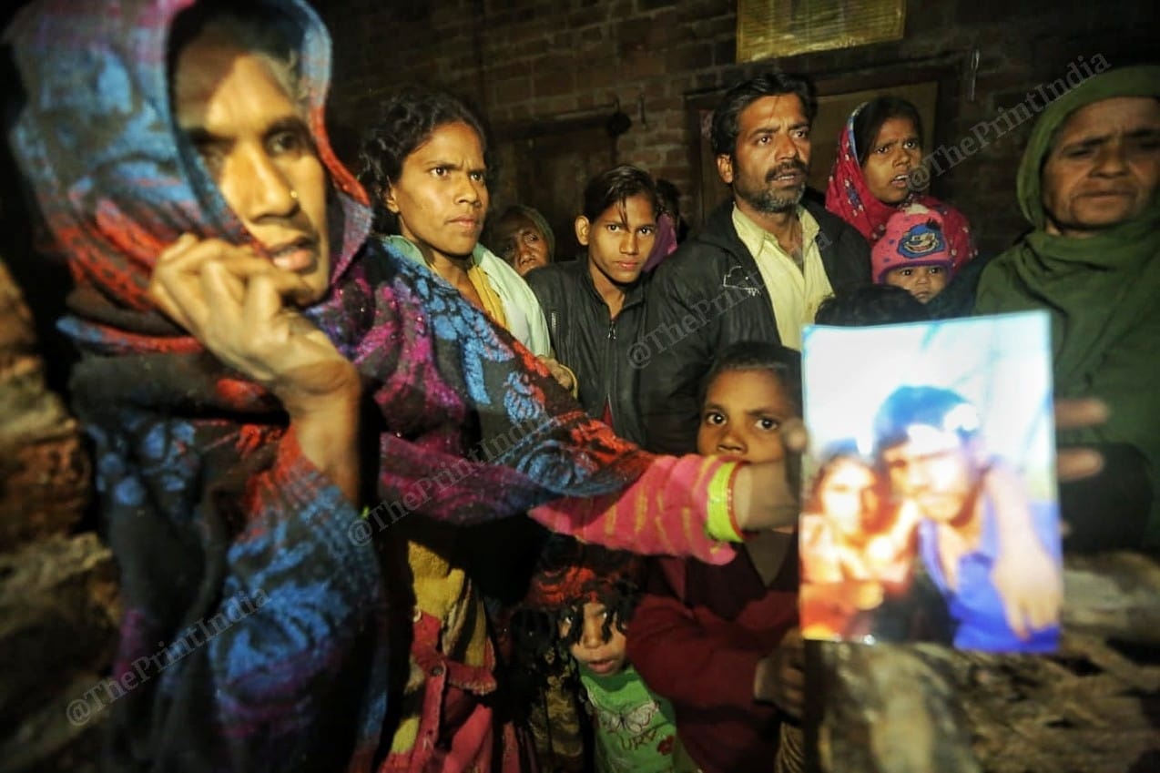 The family of Mohammad Azad hold up a photo of the couple | Photo: Praveen Jain | ThePrint