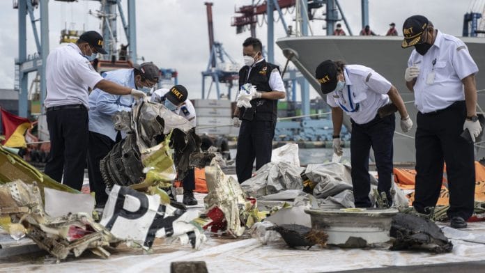 The National Transportation Safety Committee examine debris in Jakarta | Bloomberg