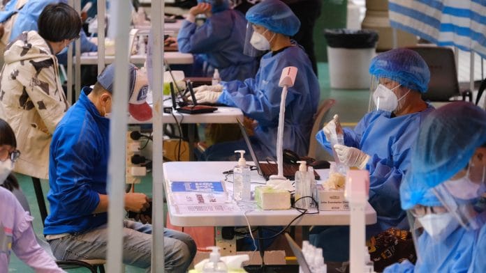 Medical workers test residents at a Covid-19 testing centre set-up in the Kowloon Bay area of Hong Kong on 10 December 2020