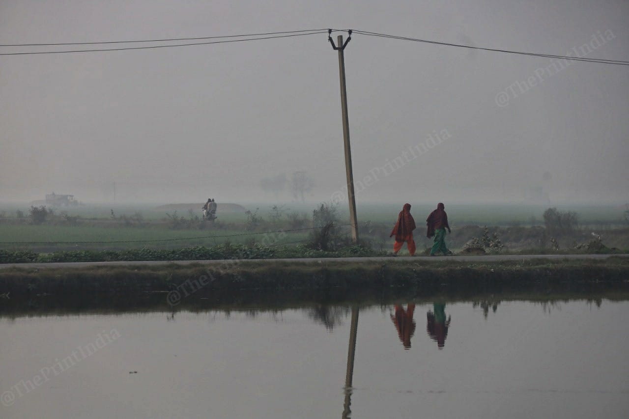 Women pass by a water body in Rugsana village | Manisha Mondal | ThePrint