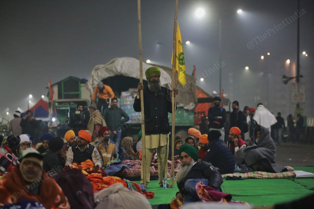 A protestors stand near the stage with the flags | Photo: Manisha Mondal | ThePrint