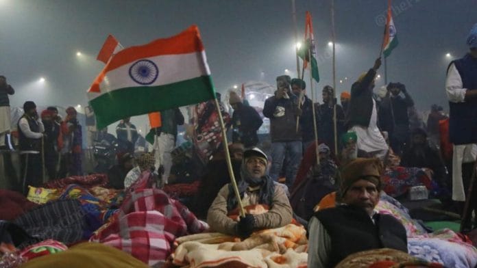 A protestor wave national flag at Ghazipur protest site | Photo: Manisha Mondal | ThePrint