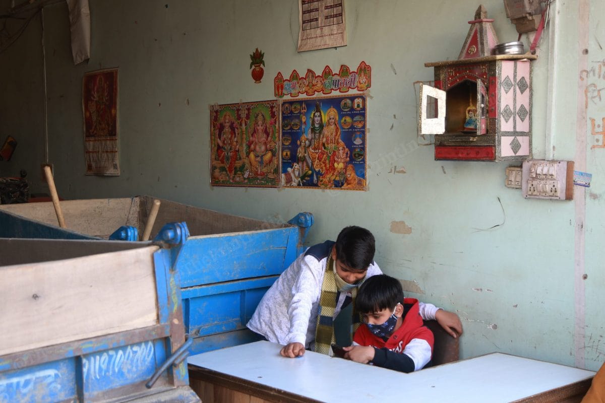Kids play inside a shop in Chand Bagh. The upper part of the shop was burnt | Photo: Manisha Mondal | ThePrint