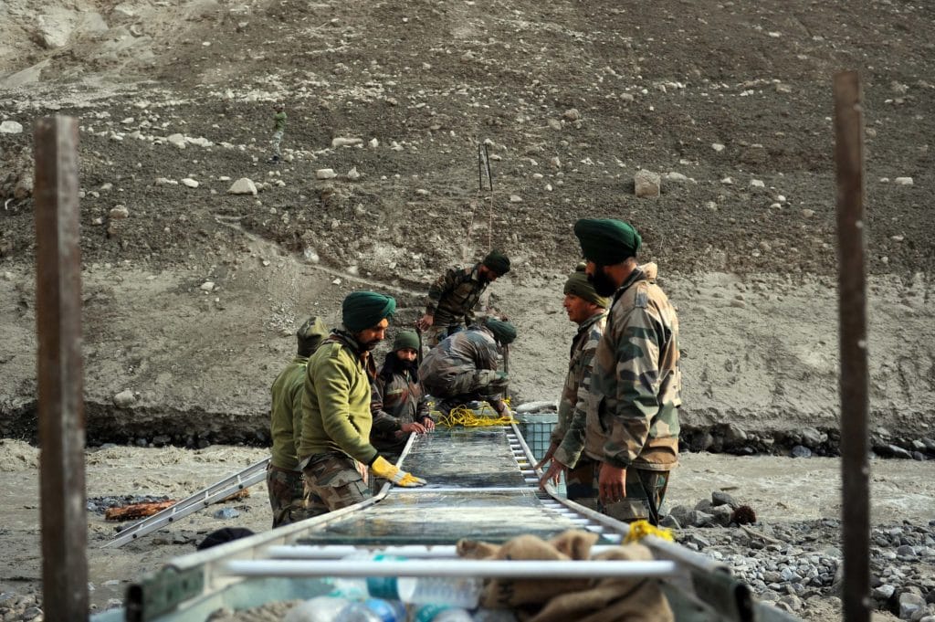 Army personnel make a temporary bridge across the Rishi Ganga river. Last Sunday's deluge broke through a bridge built across the river, cutting off access to over a dozen villages 