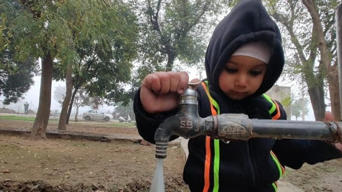 A child toys with a newly-established tap at the Panchayat Bhawan campus in Dumna village, Rupnagar | Urjita Bhardwaj | ThePrint