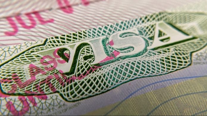 Representational image of US visa stamp on a foreign passport. | Photographer: Chris Delmas | Getty Images via Bloomberg