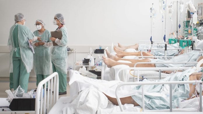 Healthcare workers hold a meeting while treating patients inside a Covid IICU at a hospital in Sao Paulo, Brazil | Bloomberg
