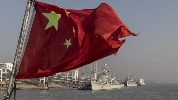 A Chinese national flag flies from a ferry on the Yangtze River in Wuhan, Hubei | Photo: Qilai Shen | Bloomberg