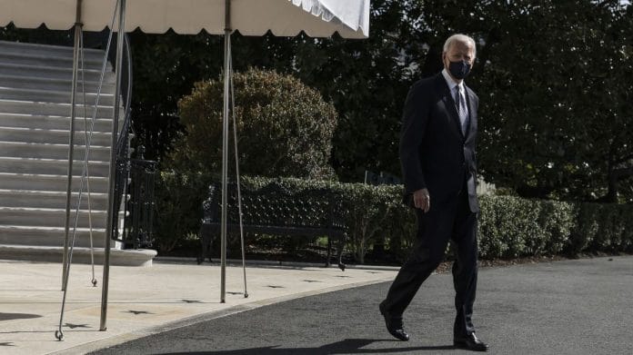 US President Joe Biden wears a protective mask while exiting the White House before boarding Marine One in Washington, DC, on 19 March 2021 | Bloomberg