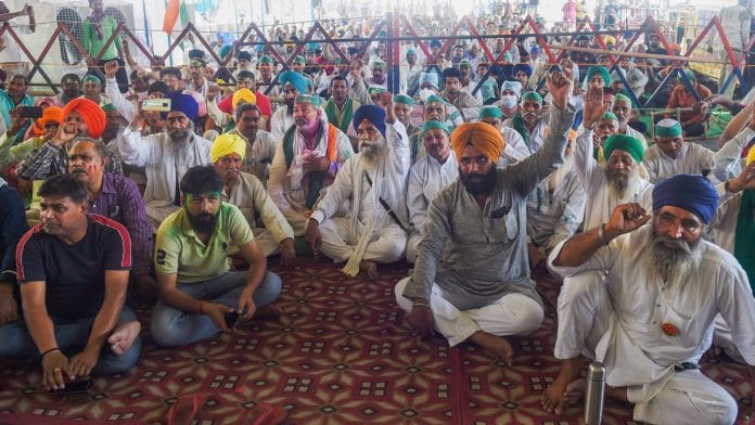 Farmers raise slogans during their ongoing protest against the new farm laws, at Ghazipur border in New Delhi on 29 March 29, 2021 | PTI