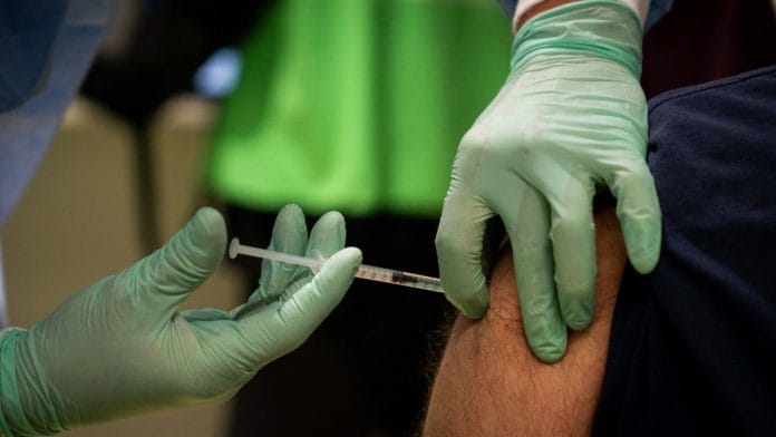 A visitor receives a dose of the AstraZeneca Plc vaccine in the Covid-19 vaccination center, set up inside the former Tegel Airport, in Berlin, Germany, on February 2021 | Photographer: Kay Nietfeld/DPA/Bloomberg