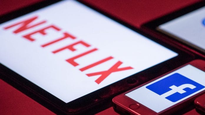 The logos for Facebook and Netflix on smartphone and tablet devices
