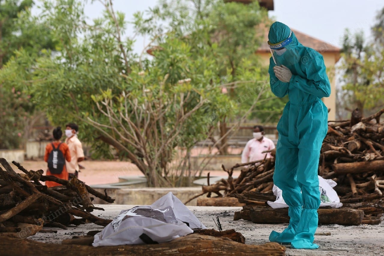 A municipal worker pays last respects to the dead body of a Covid patients. | Photo: Suraj Singh Bisht/ThePrint