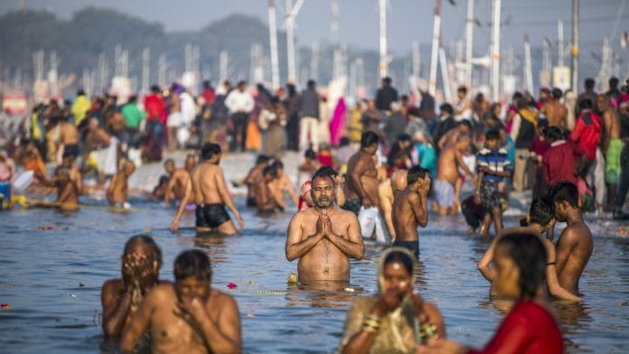 A pilgrim prays at the Sangam during the Kumbh Mela in Prayagraj, Uttar Pradesh | Bloomberg
