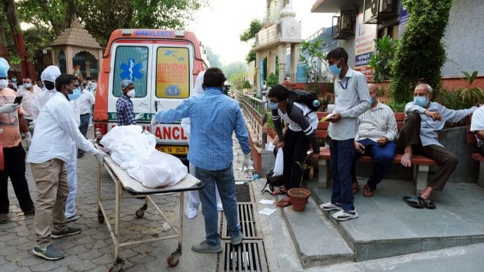 Relatives remove the shrouded body of a Covid-19 fatality from an ambulance at the Nigambodh Ghat crematorium in New Delhi India, on Monday, April 19, 2021. | Photographer: T. Narayan | Bloomberg
