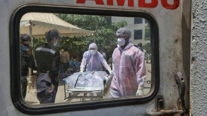 Hospital workers move a dead Covid patient, to be transported to a crematorium | Praveen Jain | ThePrint