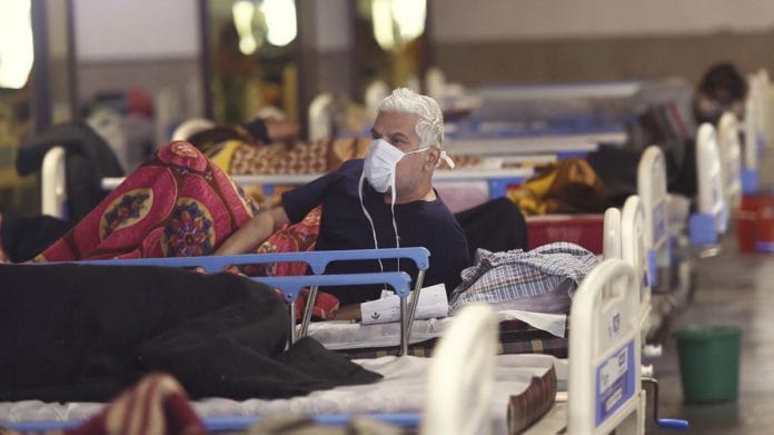 A Covid patient at Shehnai Banquet Hall, temporarily converted into an isolation ward, near Lok Nayak Hospital in New Delhi | Photo: PTI